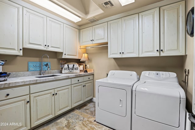 clothes washing area featuring cabinets, separate washer and dryer, and sink