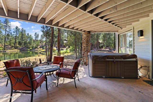 view of patio featuring a water view and a hot tub