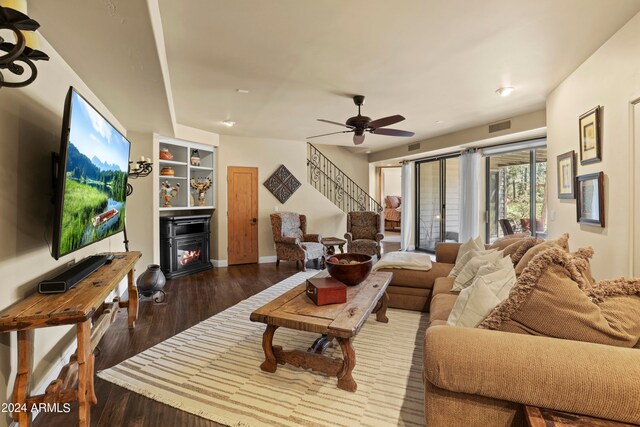 living room featuring ceiling fan and dark hardwood / wood-style floors