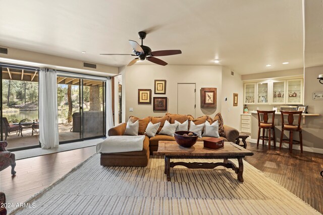 living room featuring wood-type flooring and ceiling fan