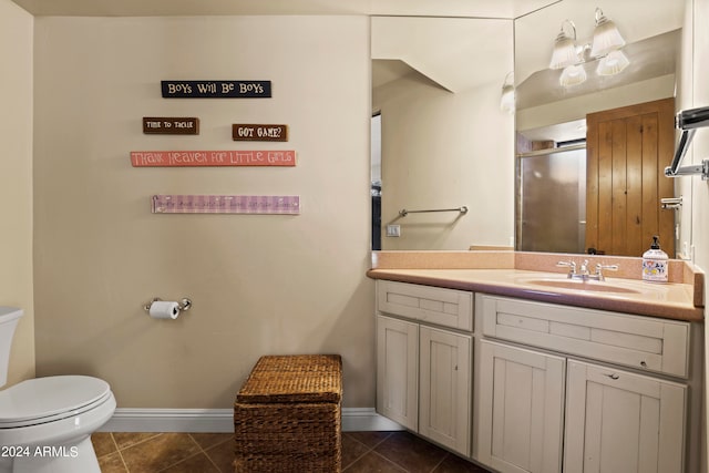 bathroom featuring tile patterned flooring, vanity, toilet, and an enclosed shower