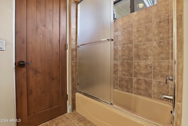 bathroom with tile patterned floors and shower / bath combination with glass door