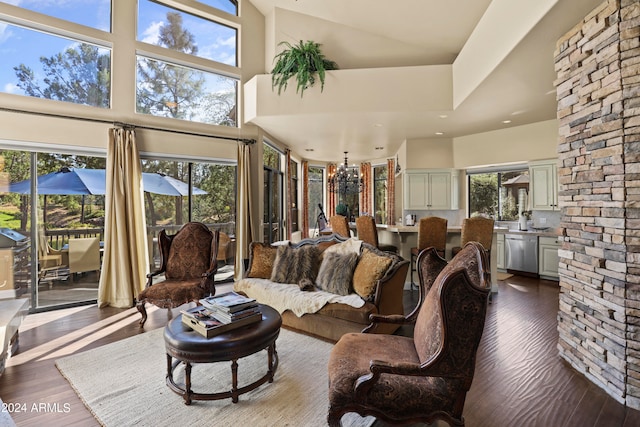 living room featuring wood-type flooring, a healthy amount of sunlight, and a high ceiling