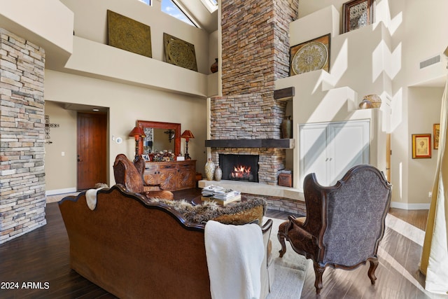 living room featuring a fireplace, hardwood / wood-style floors, and high vaulted ceiling