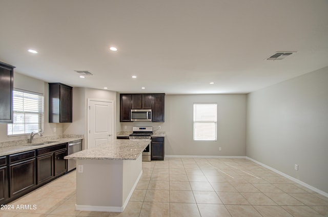 kitchen featuring light tile patterned floors, stainless steel appliances, a sink, and visible vents