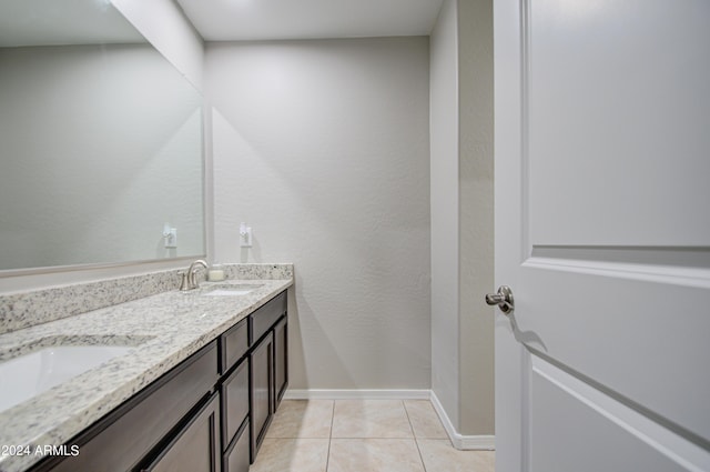 full bathroom with double vanity, baseboards, a sink, and tile patterned floors