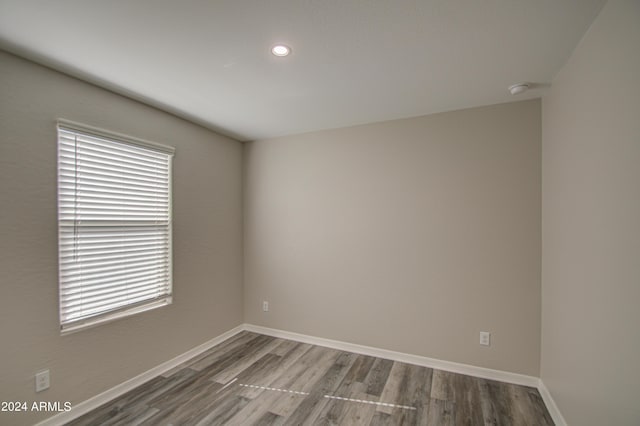 unfurnished room with plenty of natural light, baseboards, and wood finished floors