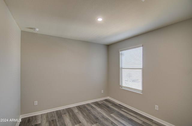 unfurnished room featuring dark wood-style floors, recessed lighting, and baseboards