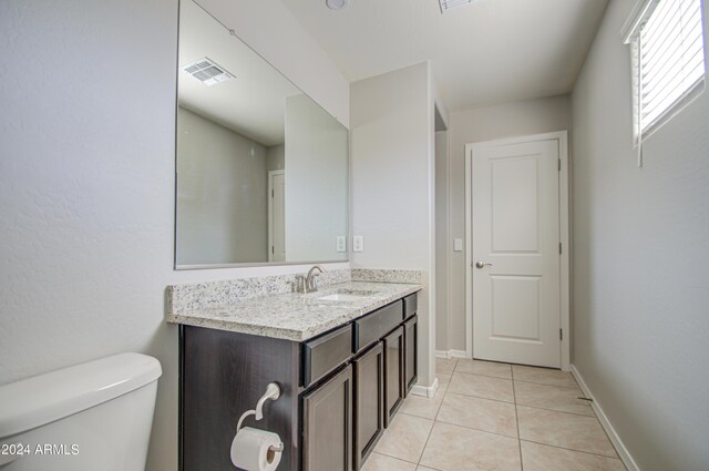 bathroom featuring visible vents, toilet, vanity, baseboards, and tile patterned floors