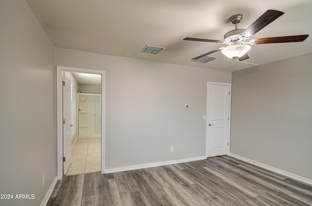 unfurnished bedroom with a ceiling fan, wood finished floors, visible vents, and baseboards