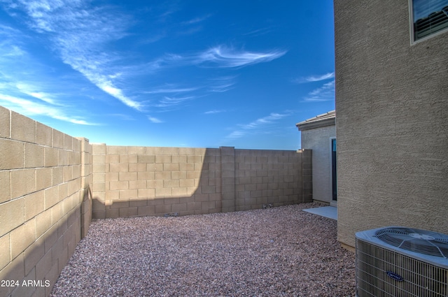 view of yard with a fenced backyard and central AC unit