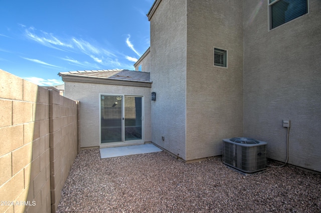 back of house with a tiled roof, fence, central AC, and stucco siding