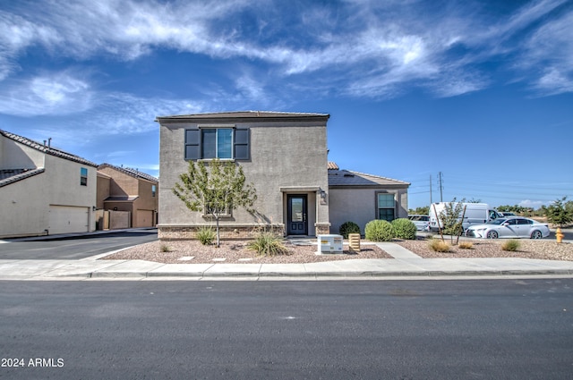 traditional-style home featuring driveway, a garage, and stucco siding