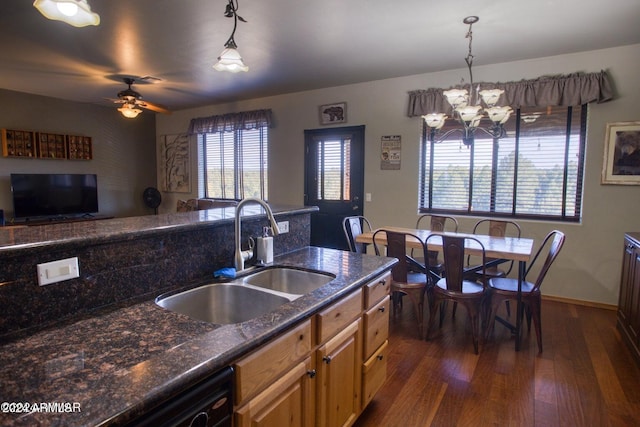 kitchen with ceiling fan with notable chandelier, dark wood-type flooring, sink, decorative light fixtures, and dark stone countertops