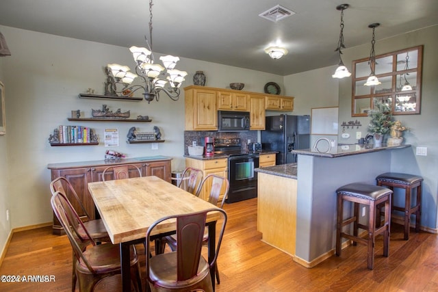 kitchen featuring a chandelier, light wood-type flooring, and black appliances