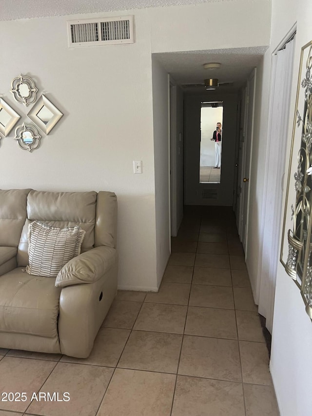 corridor featuring light tile patterned floors and visible vents