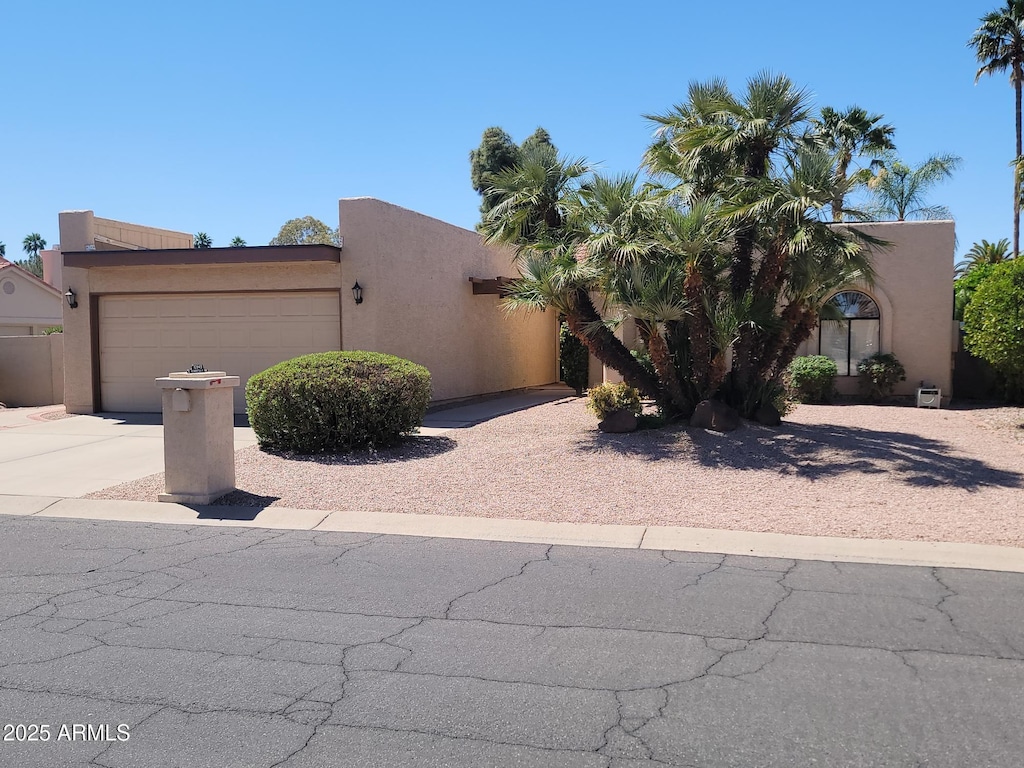 10945 E Sunnydale Dr, Sun Lakes, AZ 85248 - pueblo-style home featuring driveway, an attached garage, and stucco siding