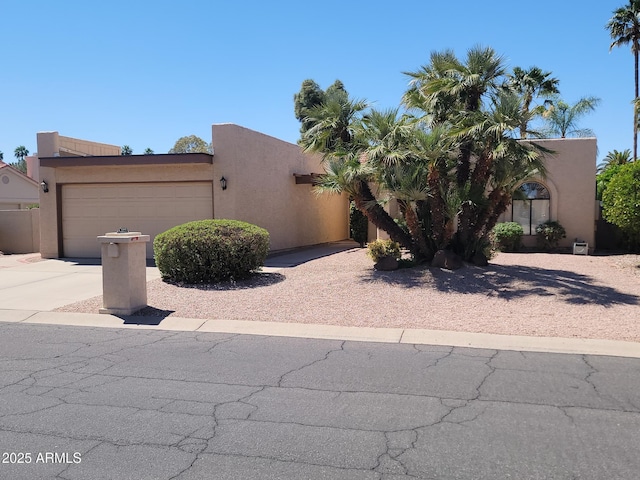 10945 E Sunnydale Dr, Sun Lakes, AZ 85248 - pueblo-style home featuring driveway, an attached garage, and stucco siding