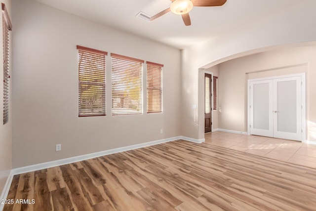 unfurnished bedroom featuring ceiling fan, light hardwood / wood-style floors, a closet, and french doors