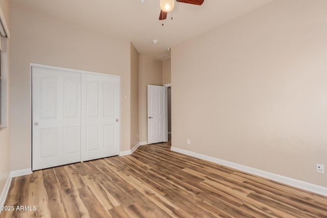 unfurnished bedroom with ceiling fan, light hardwood / wood-style floors, and a closet