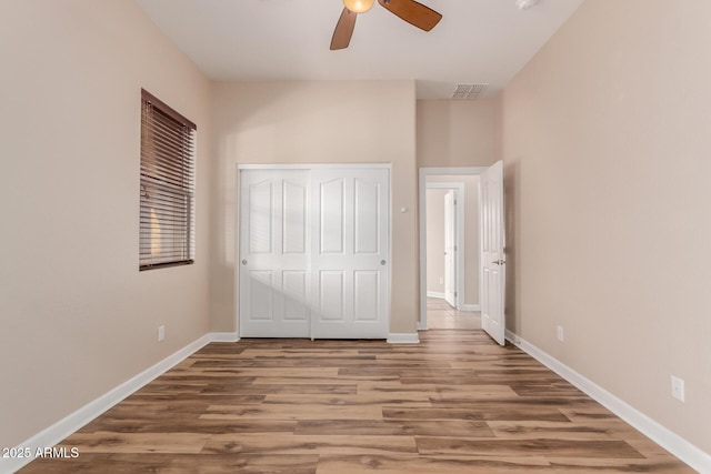 unfurnished bedroom featuring a closet, ceiling fan, and hardwood / wood-style flooring