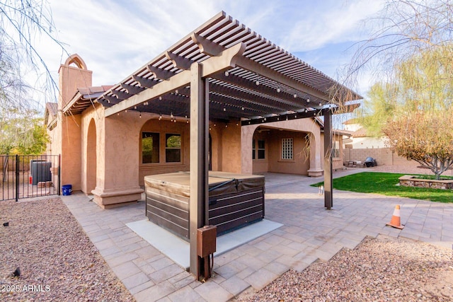 view of patio / terrace with a hot tub and a pergola