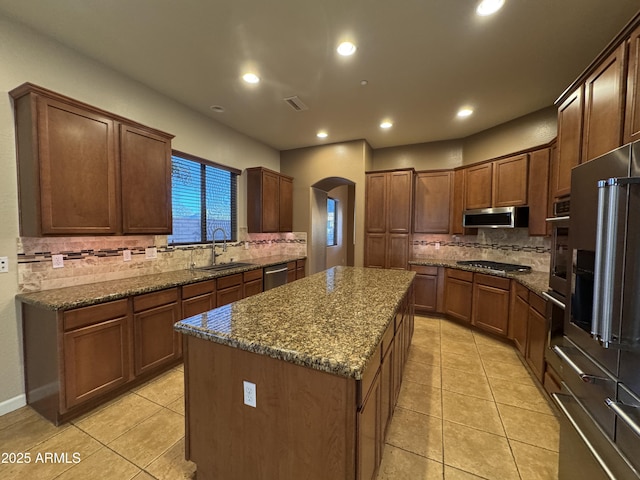 kitchen with sink, a center island, light tile patterned floors, and appliances with stainless steel finishes