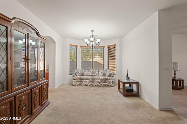 living area with an inviting chandelier and light carpet