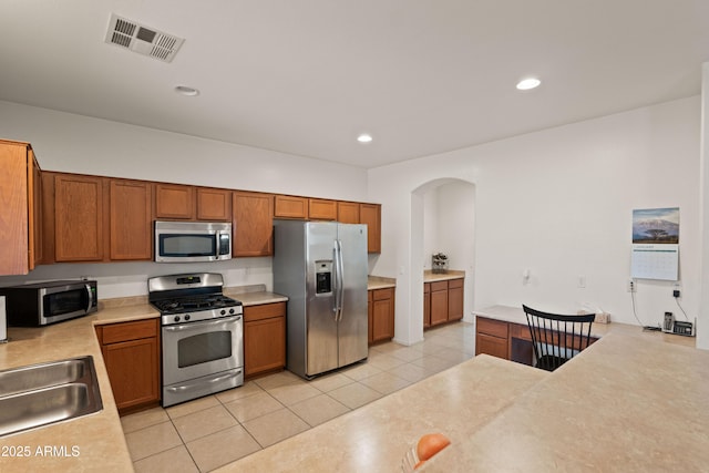 kitchen featuring sink, appliances with stainless steel finishes, and light tile patterned flooring