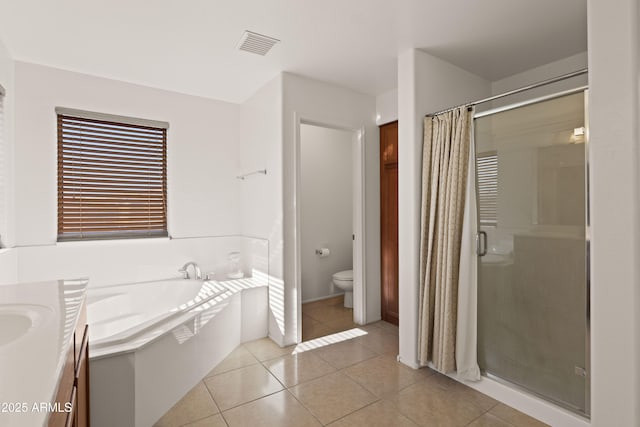 full bathroom with tile patterned floors, toilet, and independent shower and bath