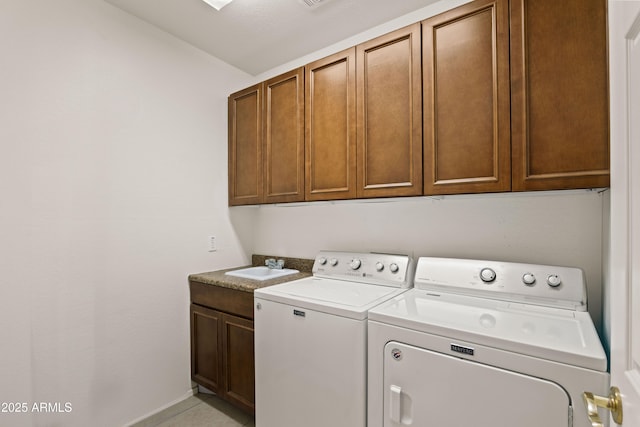 clothes washing area with sink, separate washer and dryer, and cabinets