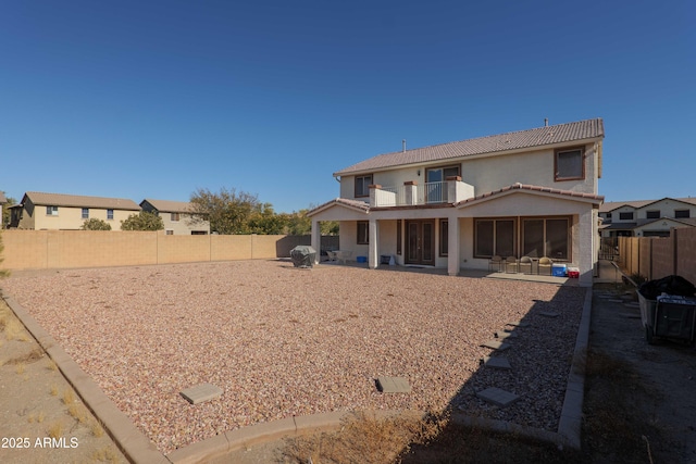 back of house with a balcony and a patio area