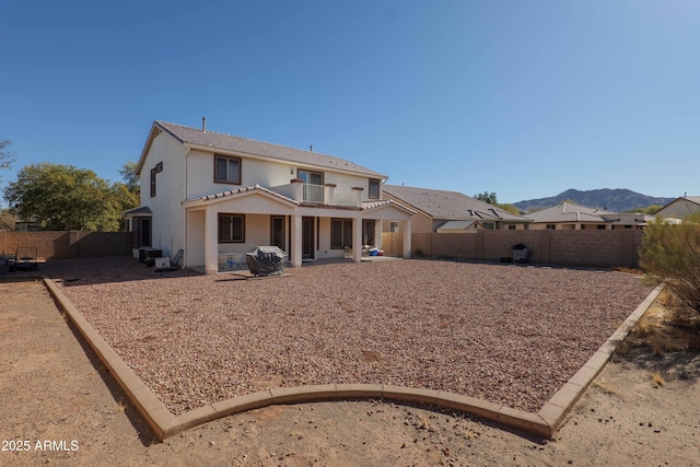 back of property featuring a balcony and a mountain view