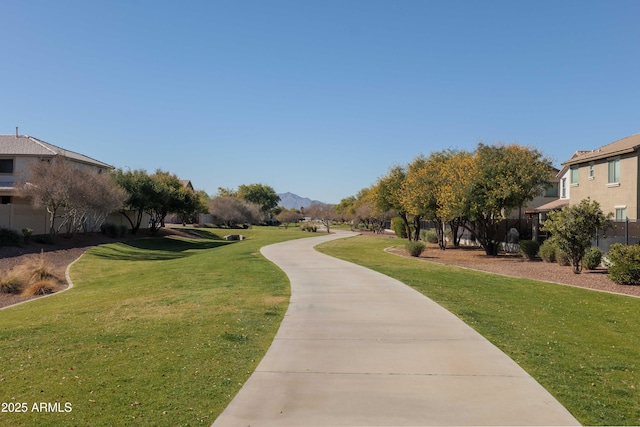 view of property's community with a mountain view and a lawn