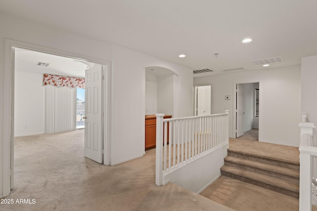 hall with light colored carpet