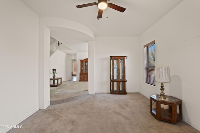 empty room with ceiling fan and light colored carpet