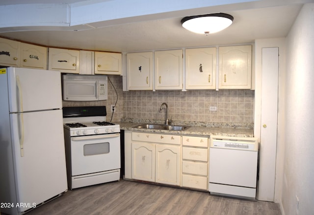 kitchen with sink, white appliances, light hardwood / wood-style floors, and backsplash