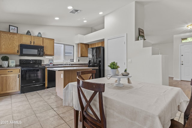 10727 E El Moro Ave, Mesa, AZ 85208 - kitchen with black appliances, a center island, light tile patterned floors, recessed lighting, and brown cabinets