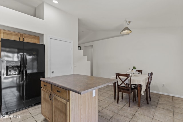 10727 E El Moro Ave, Mesa, AZ 85208 - kitchen with black fridge, vaulted ceiling, light tile patterned floors, dark countertops, and a center island