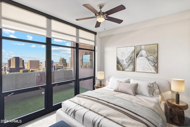 bedroom with multiple windows, ceiling fan, and a wall of windows