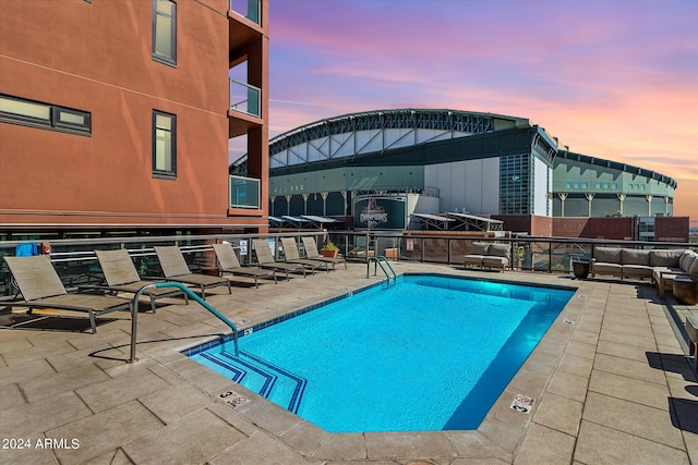 pool at dusk with a patio area