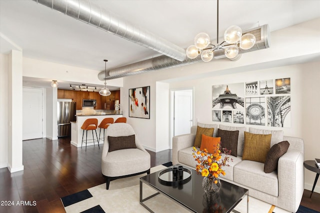 living room featuring dark hardwood / wood-style floors and an inviting chandelier