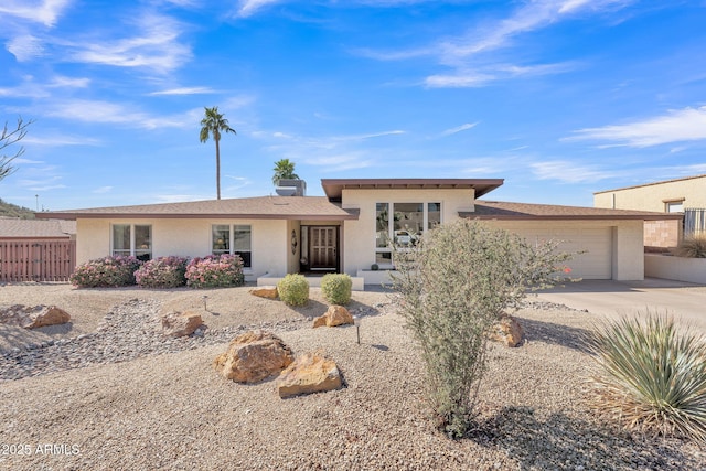 view of front of home with a garage, fence, concrete driveway, and stucco siding