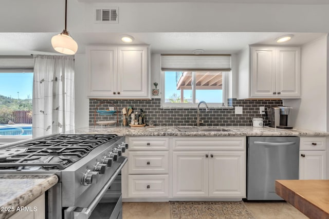 kitchen featuring stainless steel appliances, visible vents, a sink, and white cabinetry