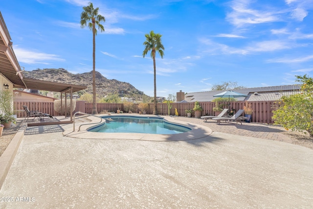 view of swimming pool with a patio, a fenced backyard, a mountain view, and a fenced in pool