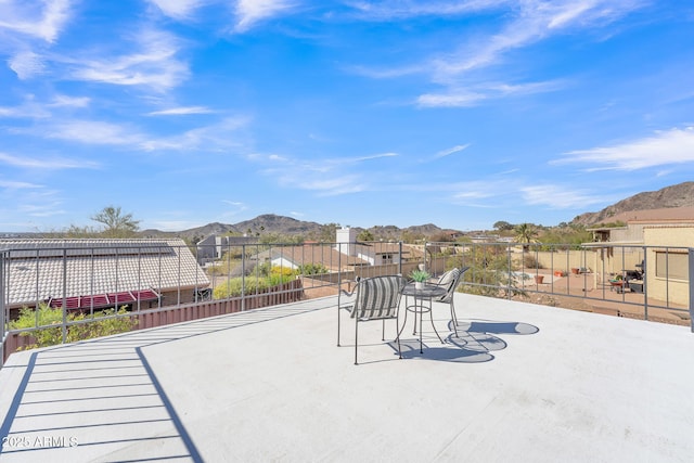 view of patio / terrace with fence and a mountain view