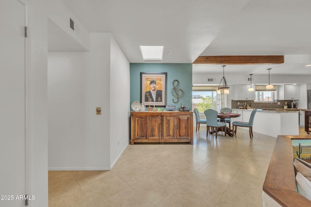 interior space featuring visible vents, beamed ceiling, baseboards, and light tile patterned floors