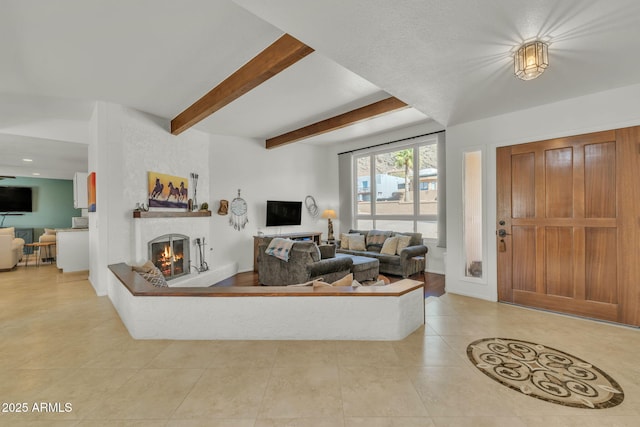 living area with a lit fireplace, beam ceiling, and tile patterned floors