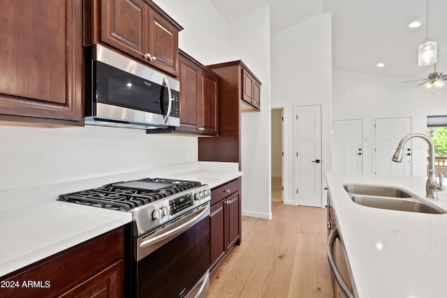 kitchen with pendant lighting, sink, ceiling fan, light wood-type flooring, and appliances with stainless steel finishes