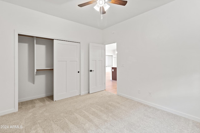 unfurnished bedroom with light carpet, a closet, and ceiling fan